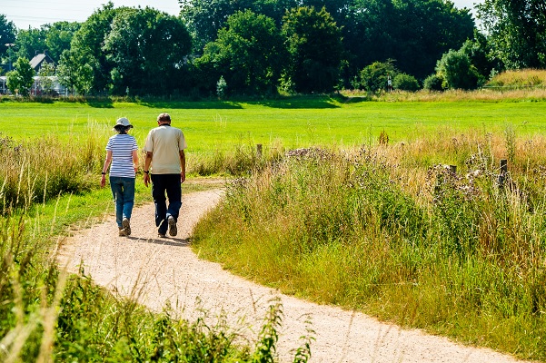 Man en vrouw wandelen in Leudal onder de stralende zomerzon