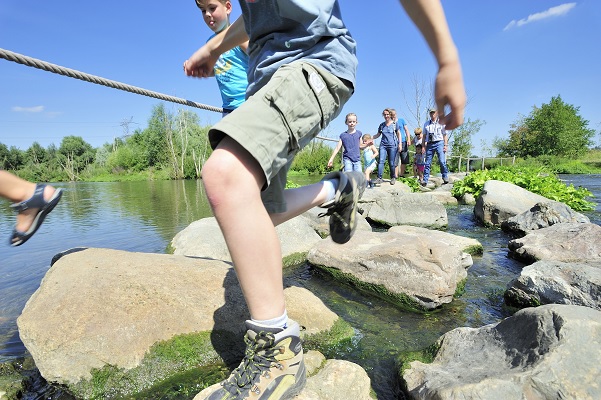 Kinderen klauteren over de Maaskeien bij het dorpje Stevensweert in de gemeente Maasgouw