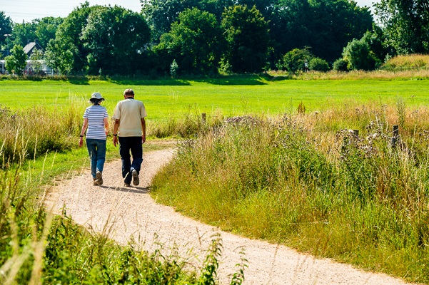 Älteres Ehepaar spaziert auf einem gewundenen Pfad durch eine grüne Landschaft in der Nähe von Buggenum in der Gemeinde Leudal