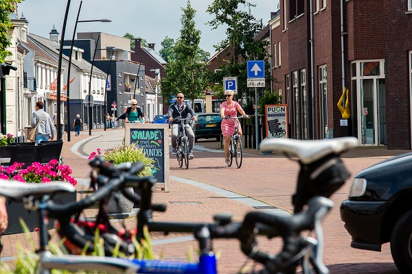 Stelletje fiets door de dorpskern van Nederweert met op de voorgrond een wielrenfiets.