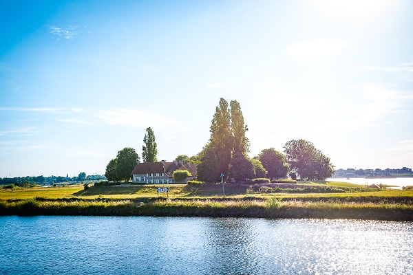 A farm in Belgian Limburg seen from the bank in Stevensweert
