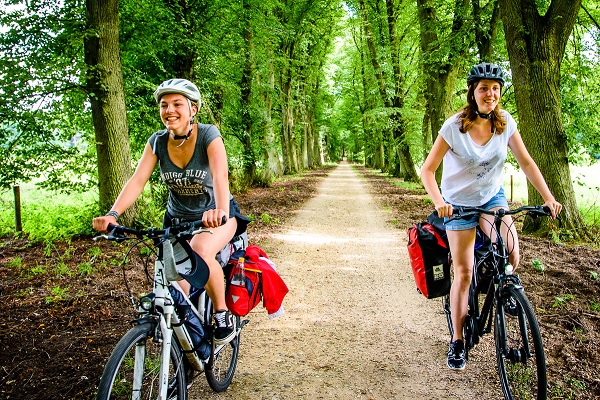 Twee vrouwen fietsen door de natuur tijdens hun fietsvakantie in Limburg
