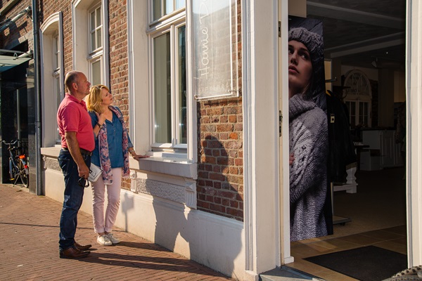 Zwei Personen betrachten ein Schaufenster in einer attraktiven historischen Straße in Heythuysen.