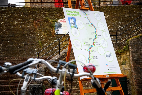 Fahrräder stehen vor einer Karte, die den gesamten Maas-Radweg zeigt