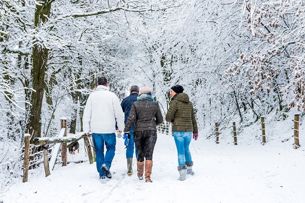 Vrienden wandelen door de sneeuw in de gemeente Roerdalen