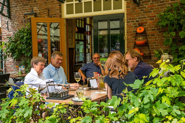 vijf mensen genieten van een drankje op het terras in Nederweert