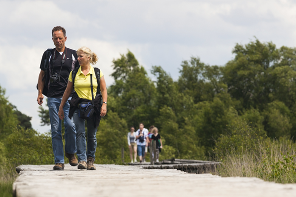 man en vrouw wandelen over een vlonderpad