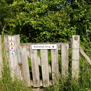 Houten poort met bordje “Romeinse brug” langs een wandelroute in natuurgebied KempenBroek.