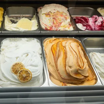 Verschillende smaken schepijs liggen in een vitrine, waaronder citroenijs, karamelijs en roomijs met discodip.
