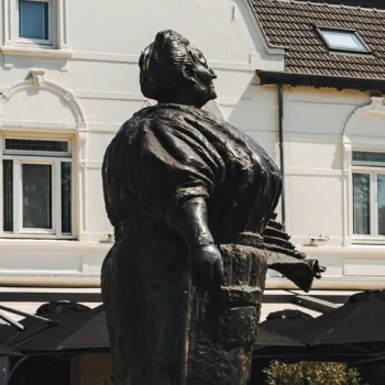 Standbeeld van Antje van de Statie in Weert, voor een wit historisch pand.